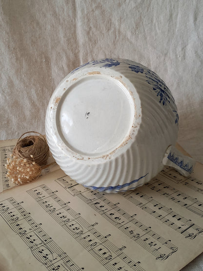 Ceramic jug with blue patterns on a sheet of music