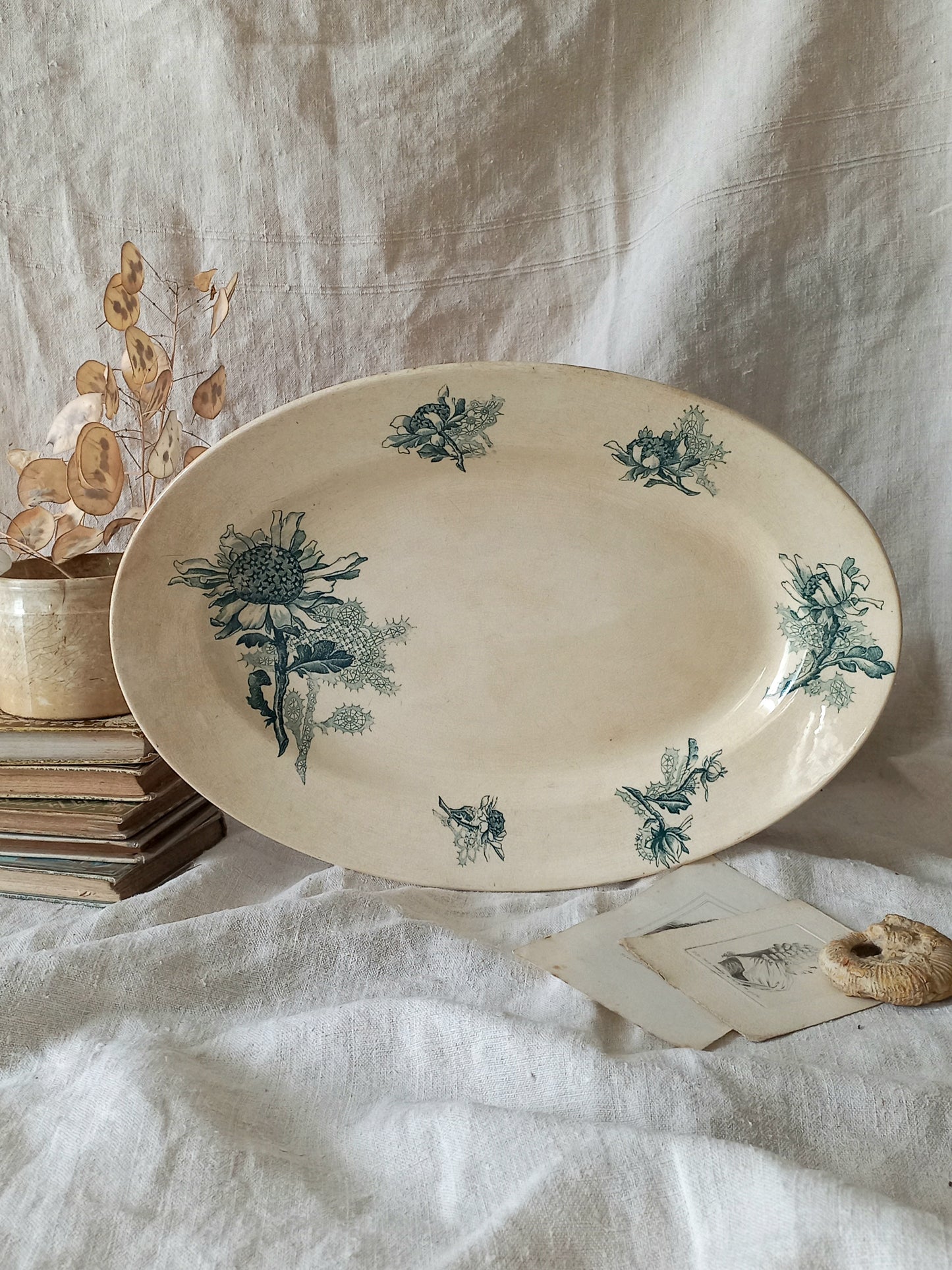 French antique oval ironstone serving plate with teal colour sunflower transferware pattern that over many decades has become a pleasing, warm shade of creamy white with crazing and tea-staining. 