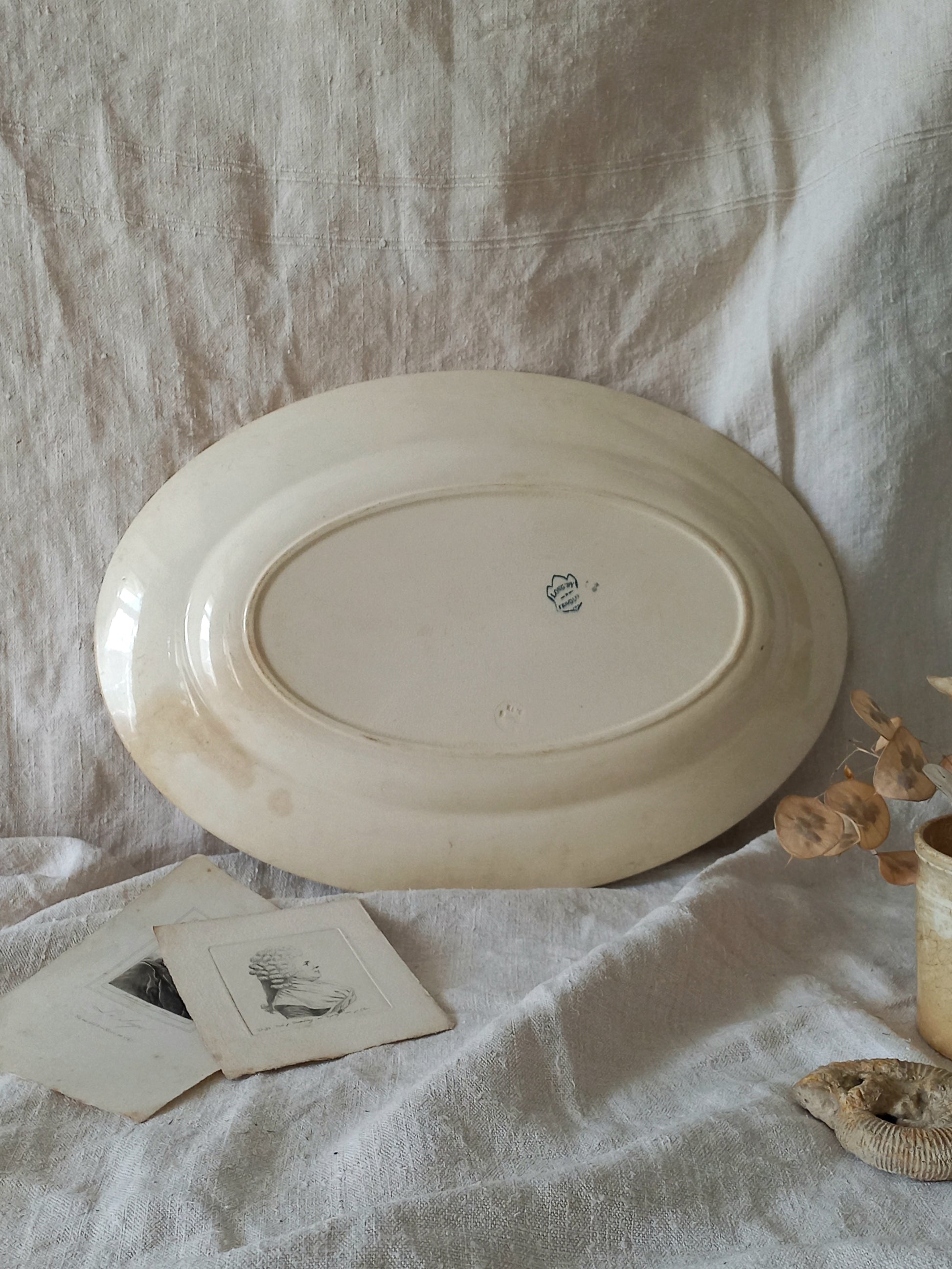 French antique oval ironstone serving plate with teal colour sunflower transferware pattern that over many decades has become a pleasing, warm shade of creamy white with crazing and tea-staining. 