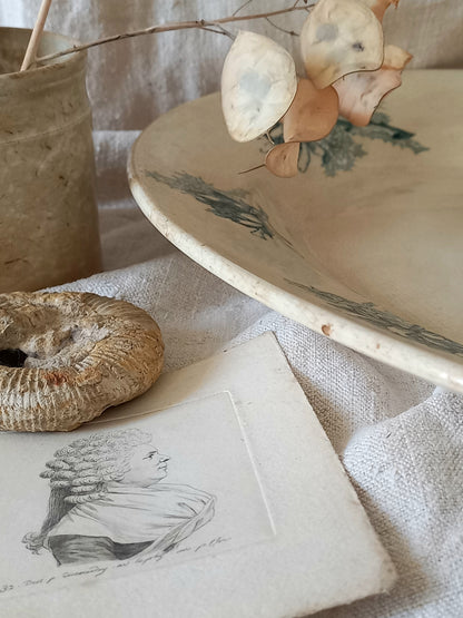 French antique oval ironstone serving plate with teal colour sunflower transferware pattern that over many decades has become a pleasing, warm shade of creamy white with crazing and tea-staining. 