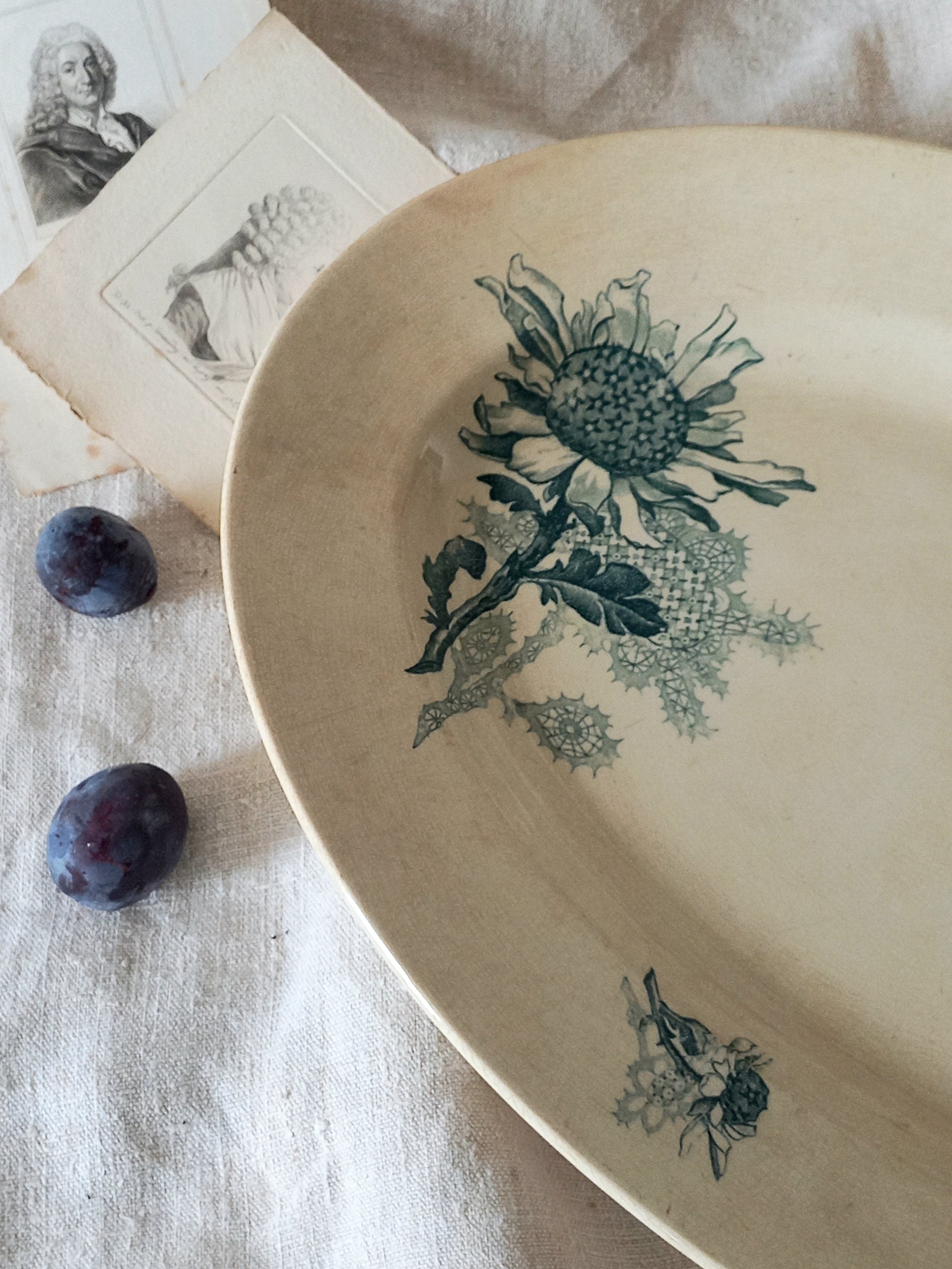 French antique oval ironstone serving plate with teal colour sunflower transferware pattern that over many decades has become a pleasing, warm shade of creamy white with crazing and tea-staining. 