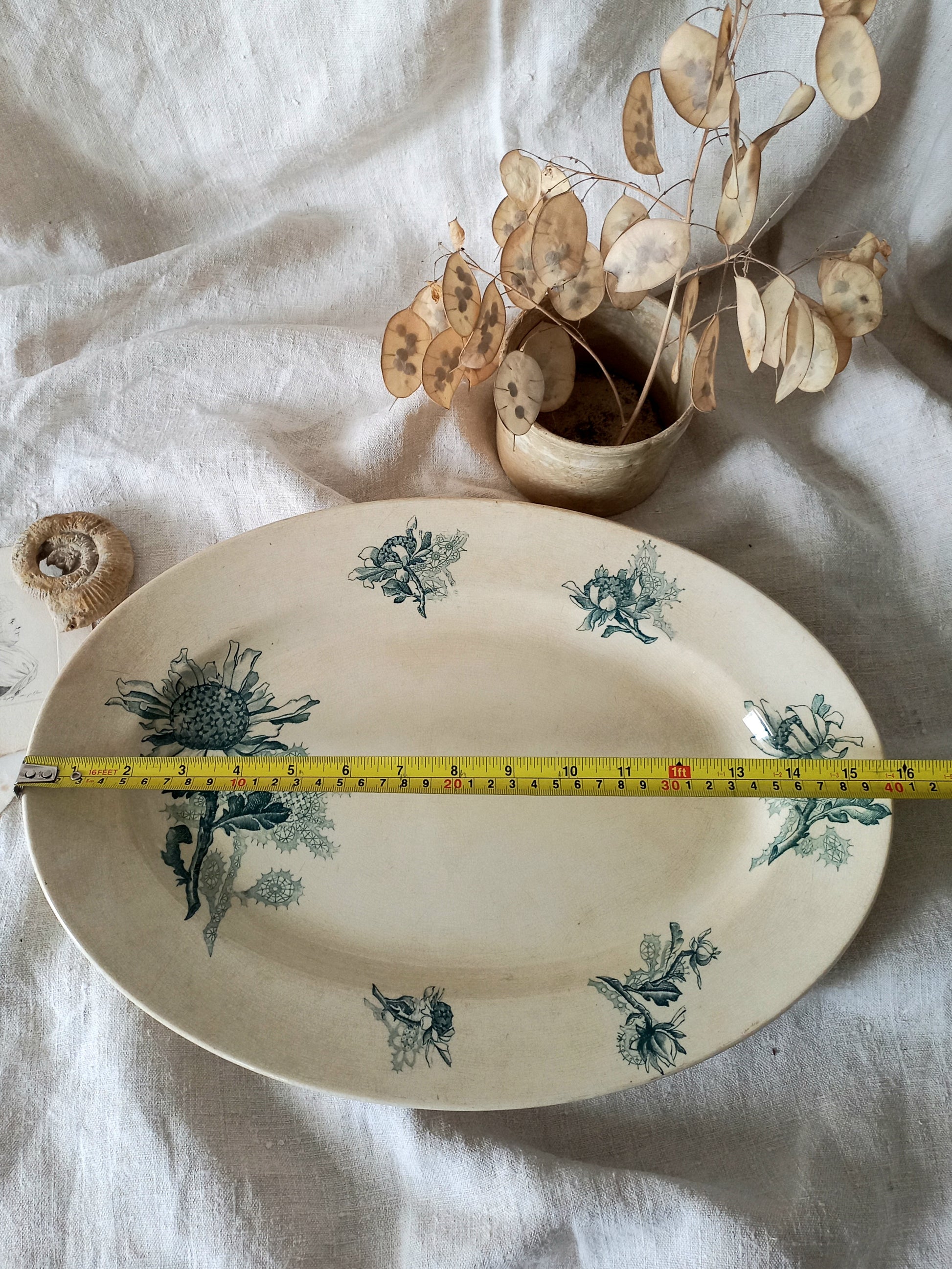 French antique oval ironstone serving plate with teal colour sunflower transferware pattern that over many decades has become a pleasing, warm shade of creamy white with crazing and tea-staining. 