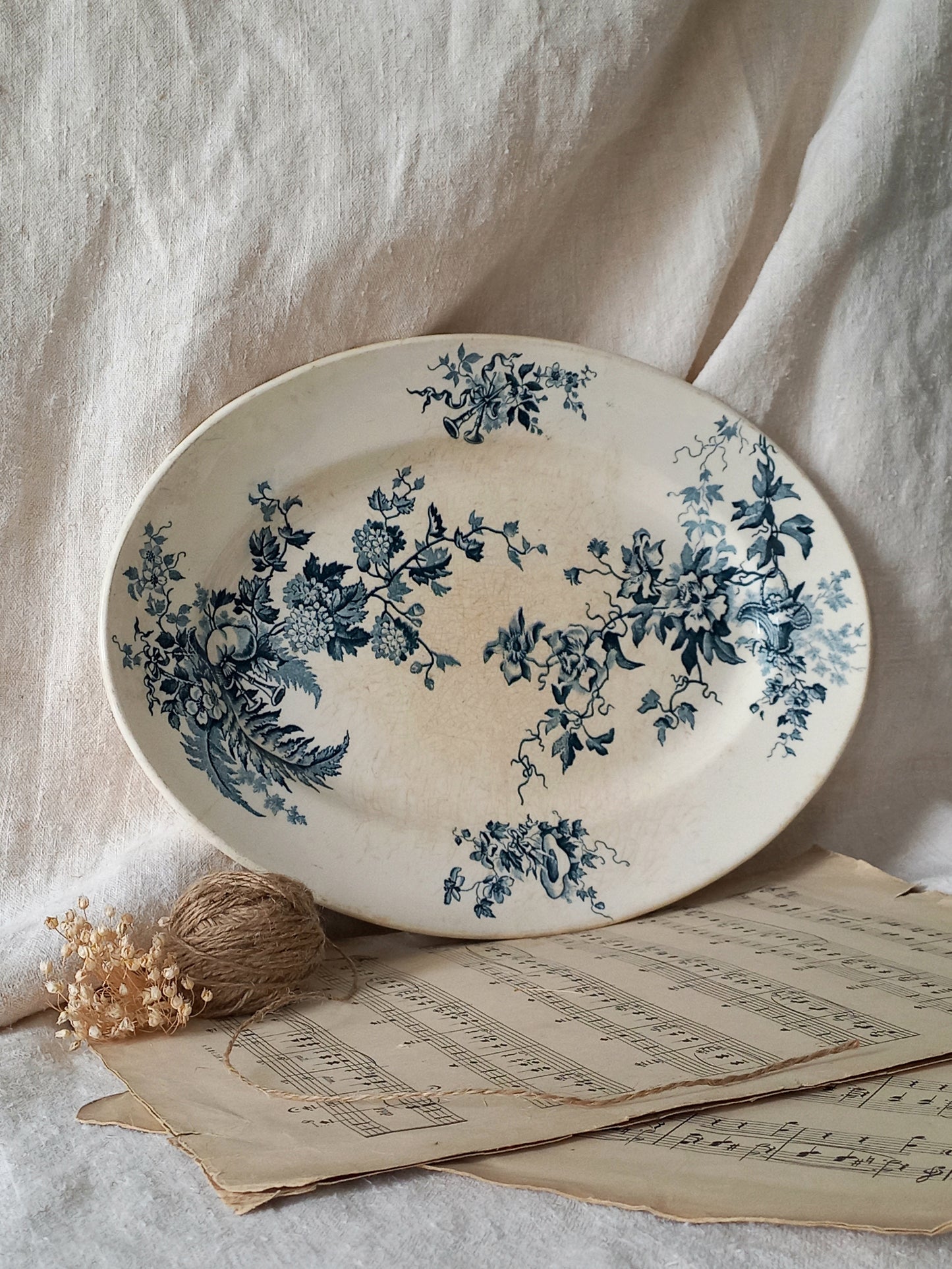 Decorative plate with blue floral patterns on a light fabric background