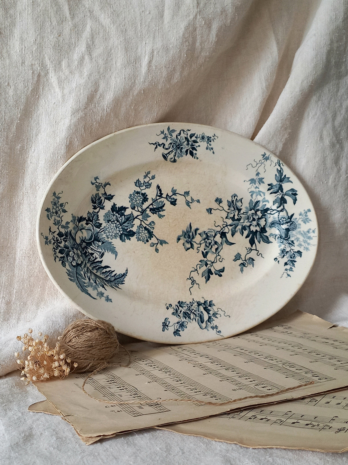 Decorative plate with blue floral patterns on a light fabric background