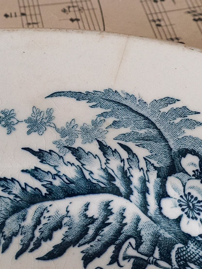 Close-up of a decorative blue pattern on a white background with music sheet in the background