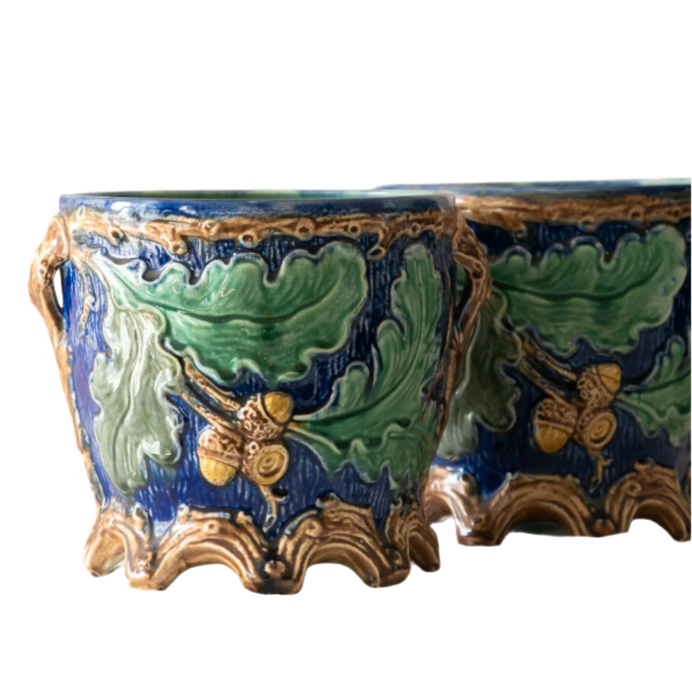 A stunning pair of French antique majolica planters, absolutely glorious fresh blue and green colours with oak leafs and acorns in relief making these stunning pieces of interior home decor wherever you decide to display them.

One of the planters has an antique repair in the form of metal staples that have been expertly done from the inside - in the 1800s and early 1900s this was quite a common repair to have made on items of high value and we feel it only adds to the authenticity/story of these pieces.