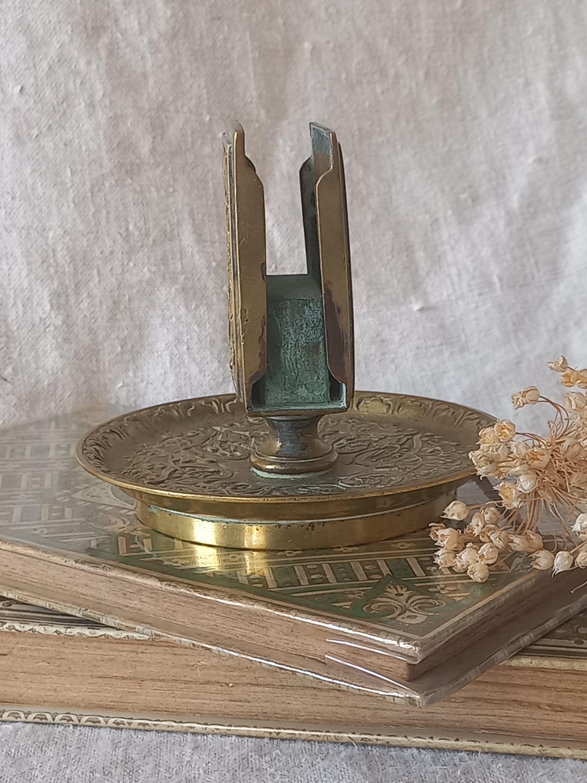 Close-up of a French antique decorative brass-coated matchbox holder in a decorative setting.