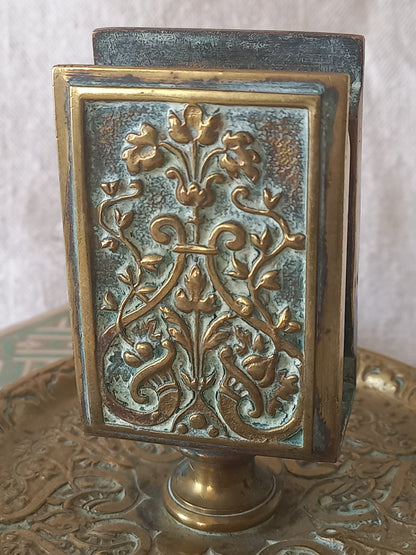French antique decorative brass-coated matchbox holder in a decorative setting.