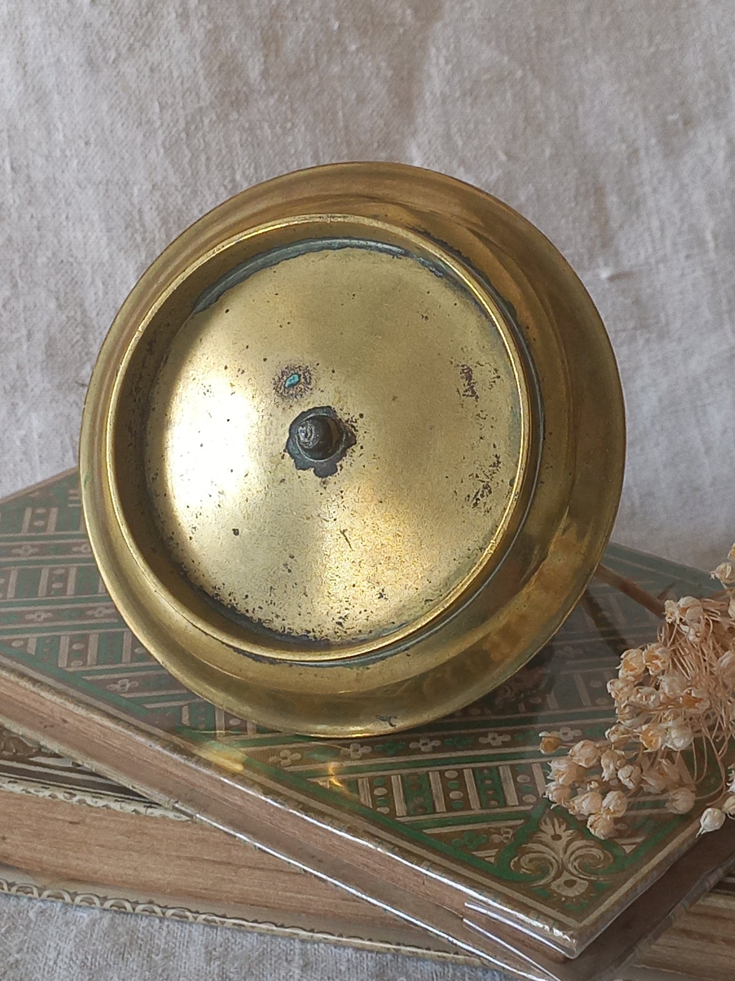 Close-up of a French antique decorative brass-coated matchbox holder in a decorative setting.