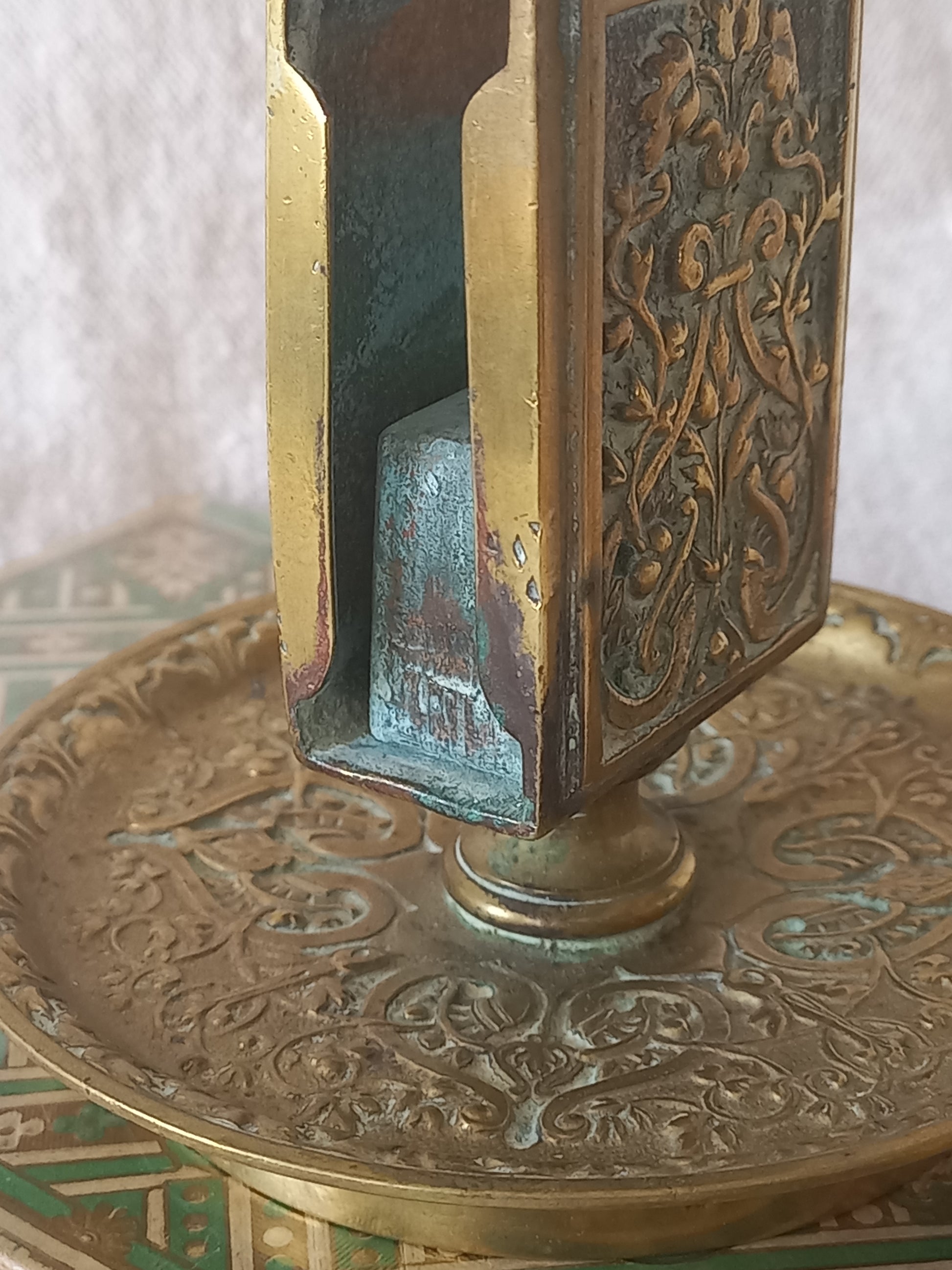 Close-up of a French antique decorative brass-coated matchbox holder in a decorative setting.