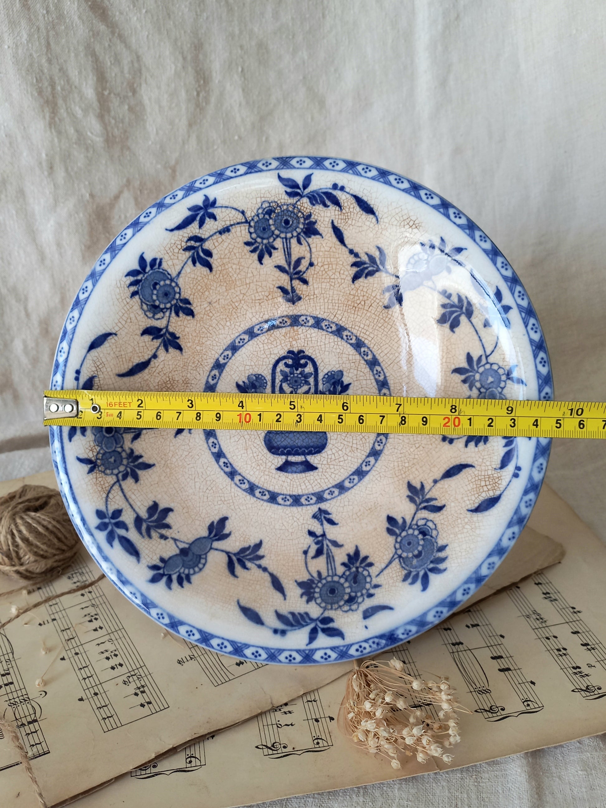 An antique footed dish by Minton with a tape measure for reference.