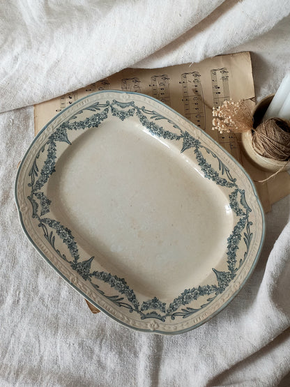 French antique aged white ironstone plate/platter with pretty blue floral pattern on a surface with sheet music and decorative items.