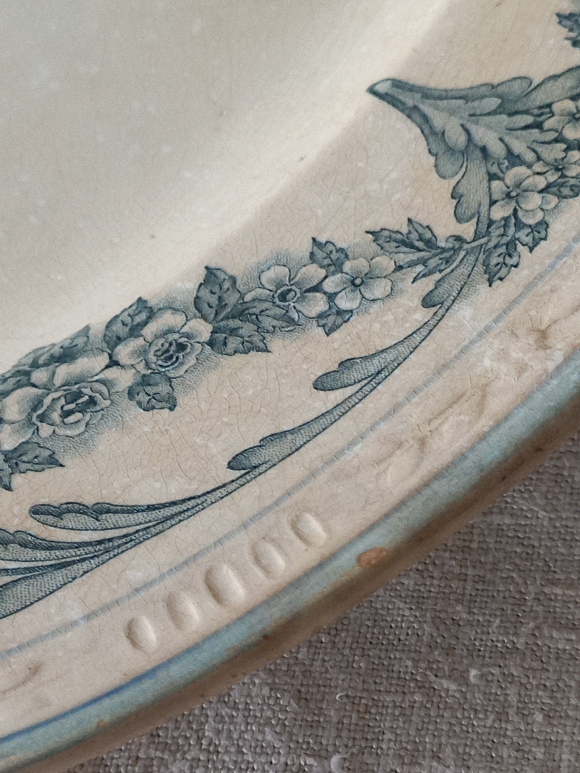 Close-up of a ceramic plate with floral design on a textured surface