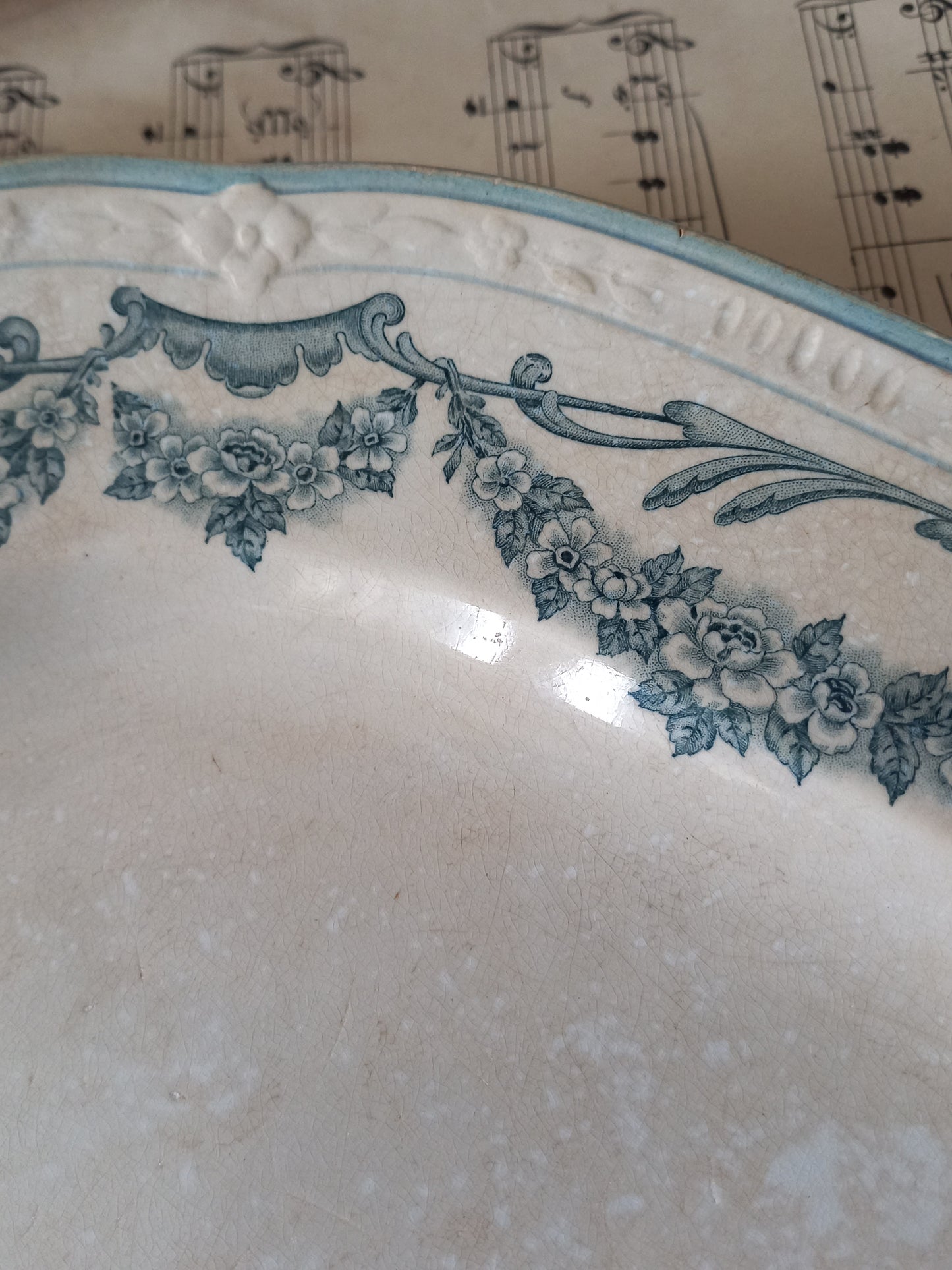 Decorative plate with floral patterns on a surface with music sheet background