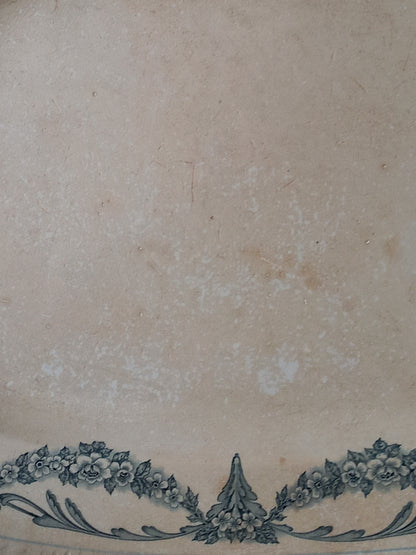 Close-up of antique aged white ironstone plate/platter with pretty blue floral pattern.