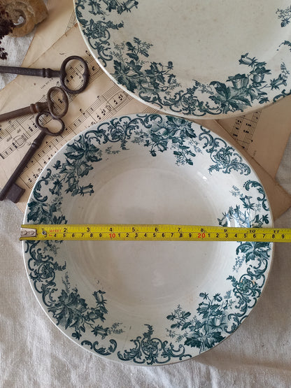 Two ceramic plates with floral patterns and a measuring tape between them on a textured surface.