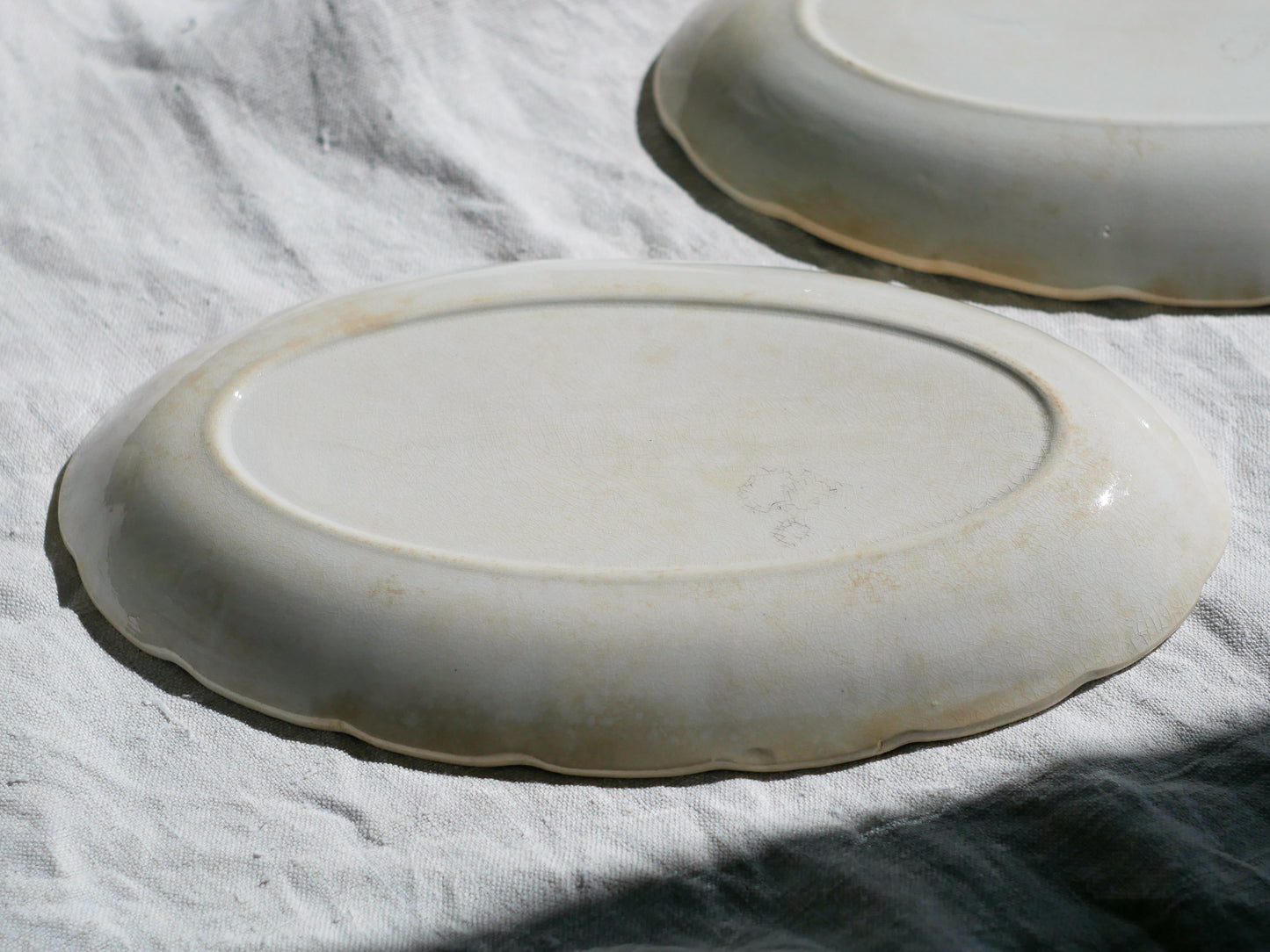 A beautiful pair of French antique ironstone raviers or side plates which over the last century or more have developed a wonderful time-worn and tea-stained finish which make them perfect for shabby chic interior decor. We very rarely come across these little plates lately they're a rare find.