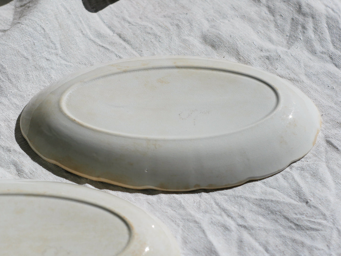 A beautiful pair of French antique ironstone raviers or side plates which over the last century or more have developed a wonderful time-worn and tea-stained finish which make them perfect for shabby chic interior decor. We very rarely come across these little plates lately they're a rare find.