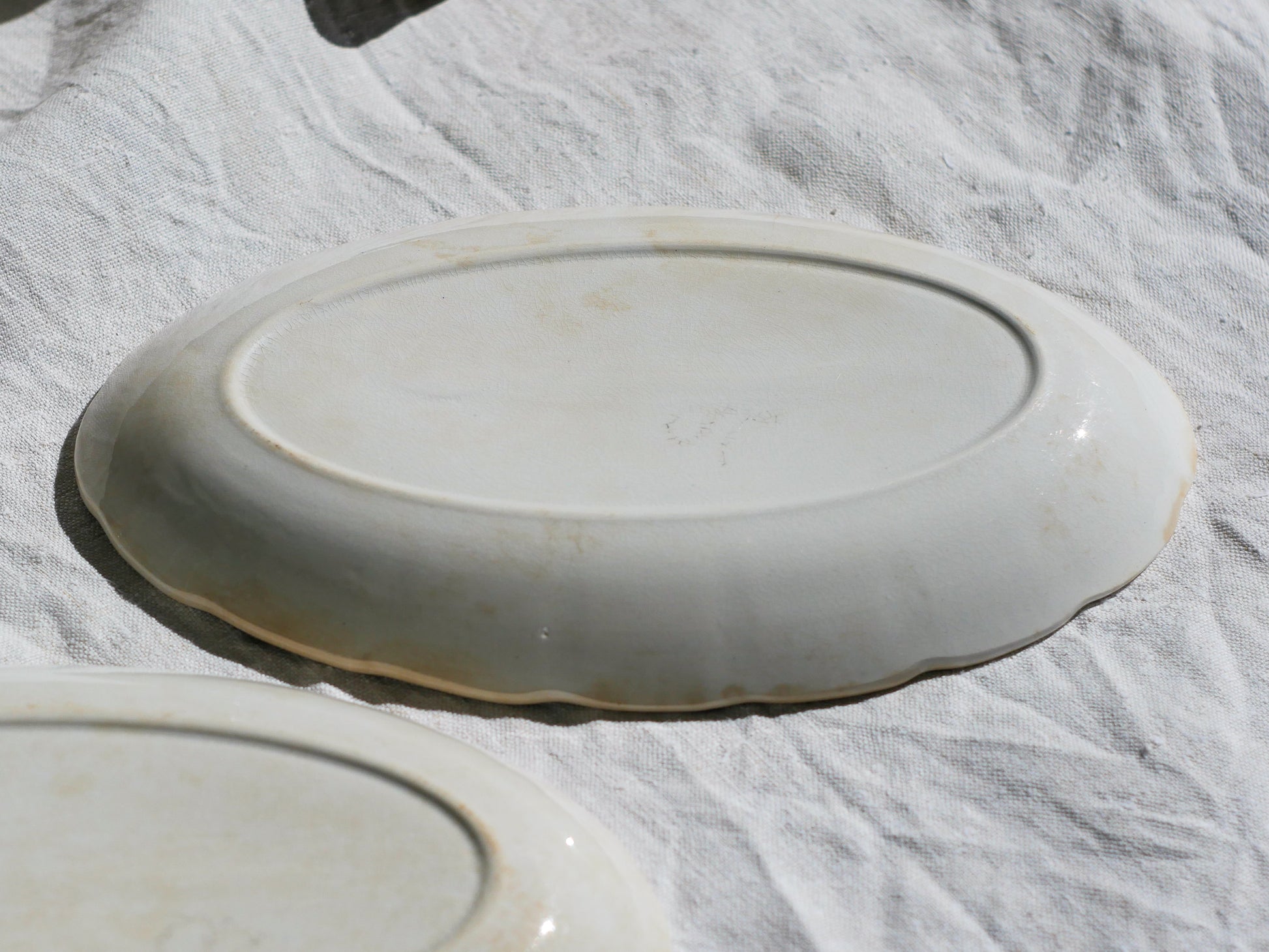 A beautiful pair of French antique ironstone raviers or side plates which over the last century or more have developed a wonderful time-worn and tea-stained finish which make them perfect for shabby chic interior decor. We very rarely come across these little plates lately they're a rare find.