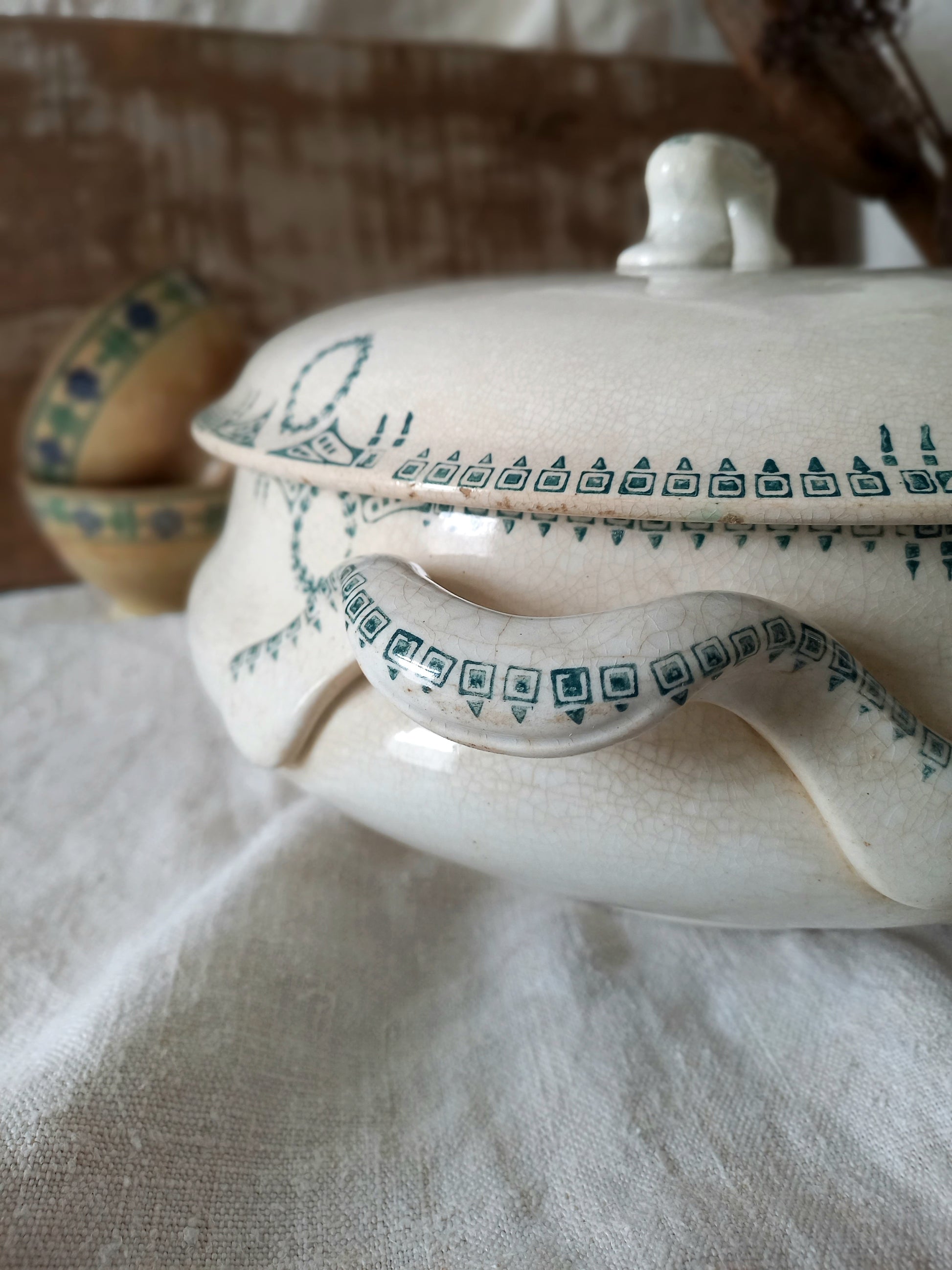 Ceramic dish with green patterns on a white fabric background