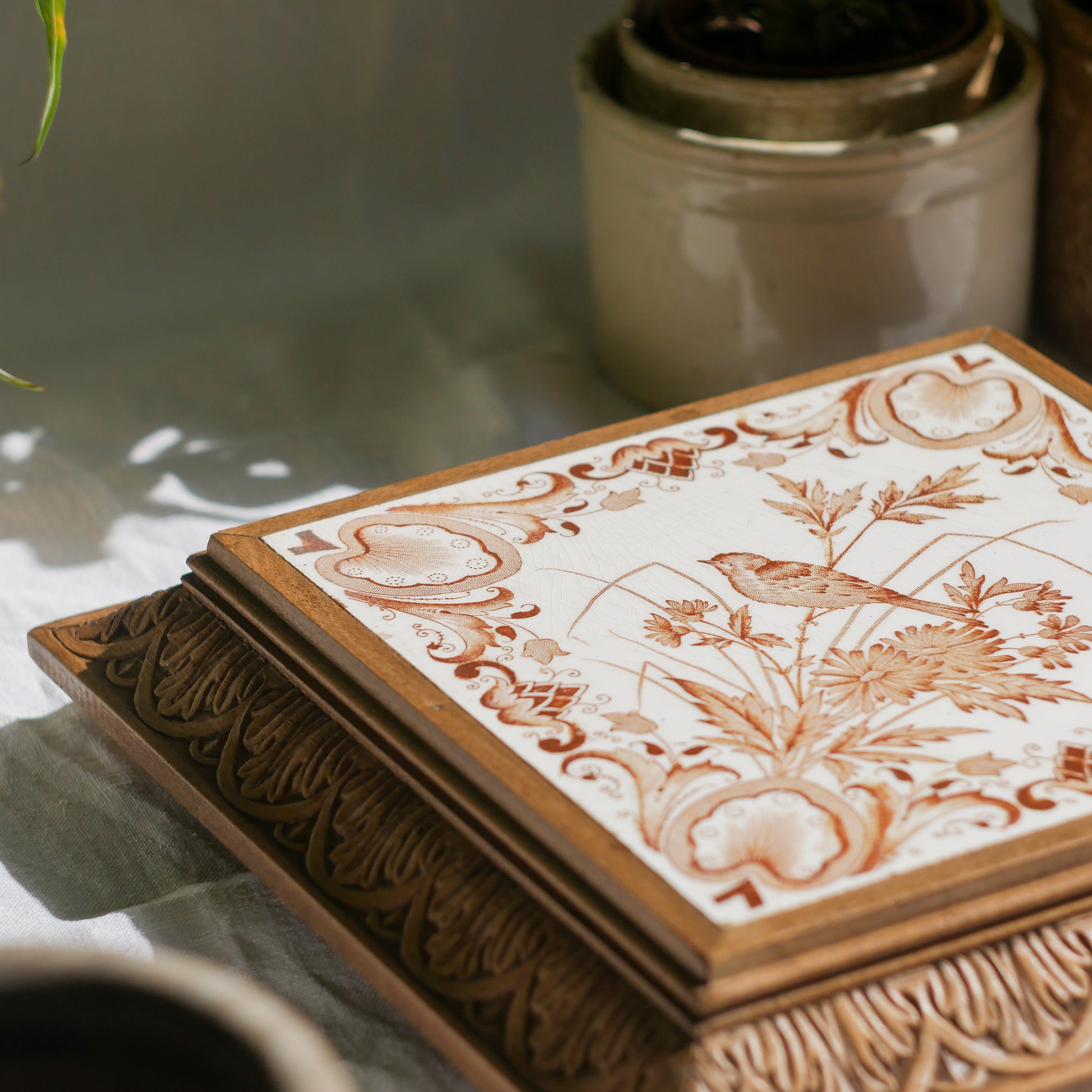 A beautiful French antique wooden trivet with a ceramic bird and floral tile insert. The wooden frame is very decorative with patterns around all four edges while the ceramic tile has aged just enough, the tasteful off-white and light brown colour scheme making this piece a most welcome addition to any kitchen as decor or perhaps as a decorative plant pot stand.