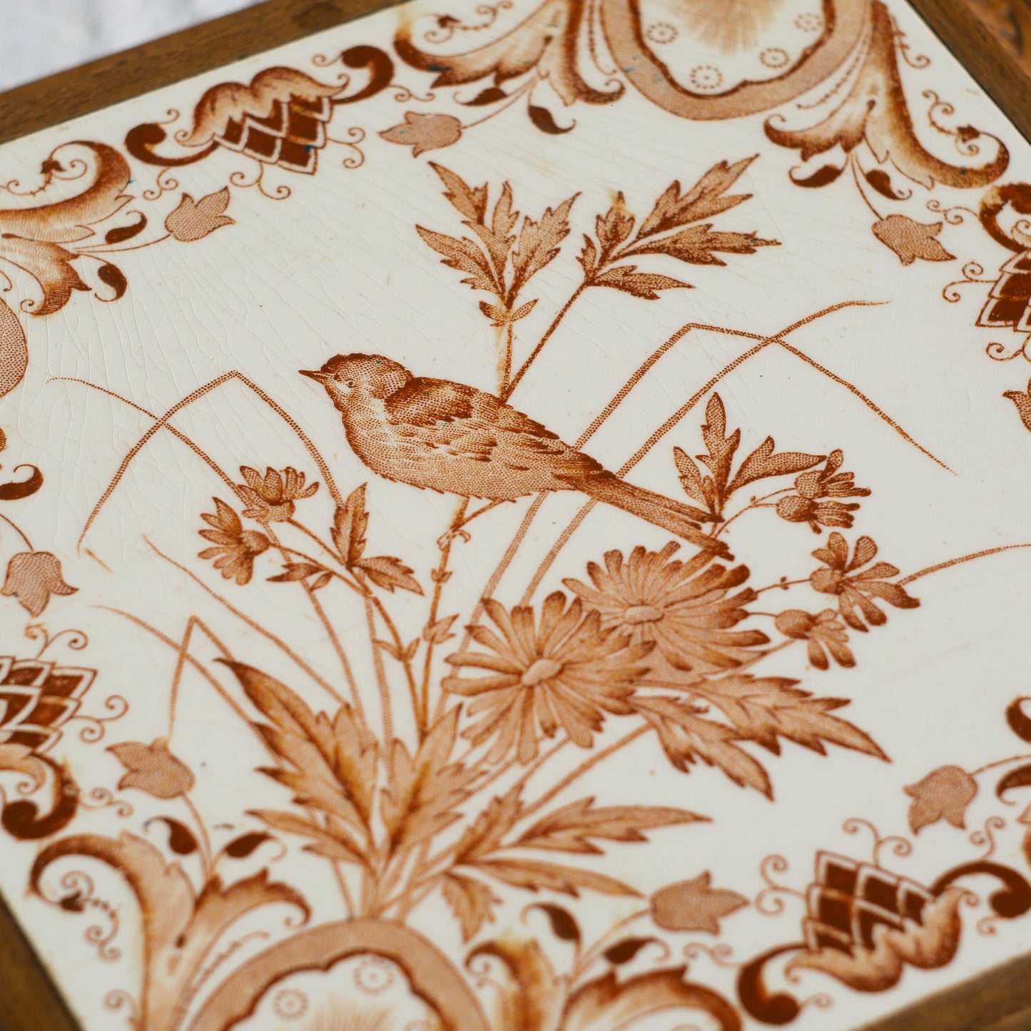 A beautiful French antique wooden trivet with a ceramic bird and floral tile insert. The wooden frame is very decorative with patterns around all four edges while the ceramic tile has aged just enough, the tasteful off-white and light brown colour scheme making this piece a most welcome addition to any kitchen as decor or perhaps as a decorative plant pot stand.