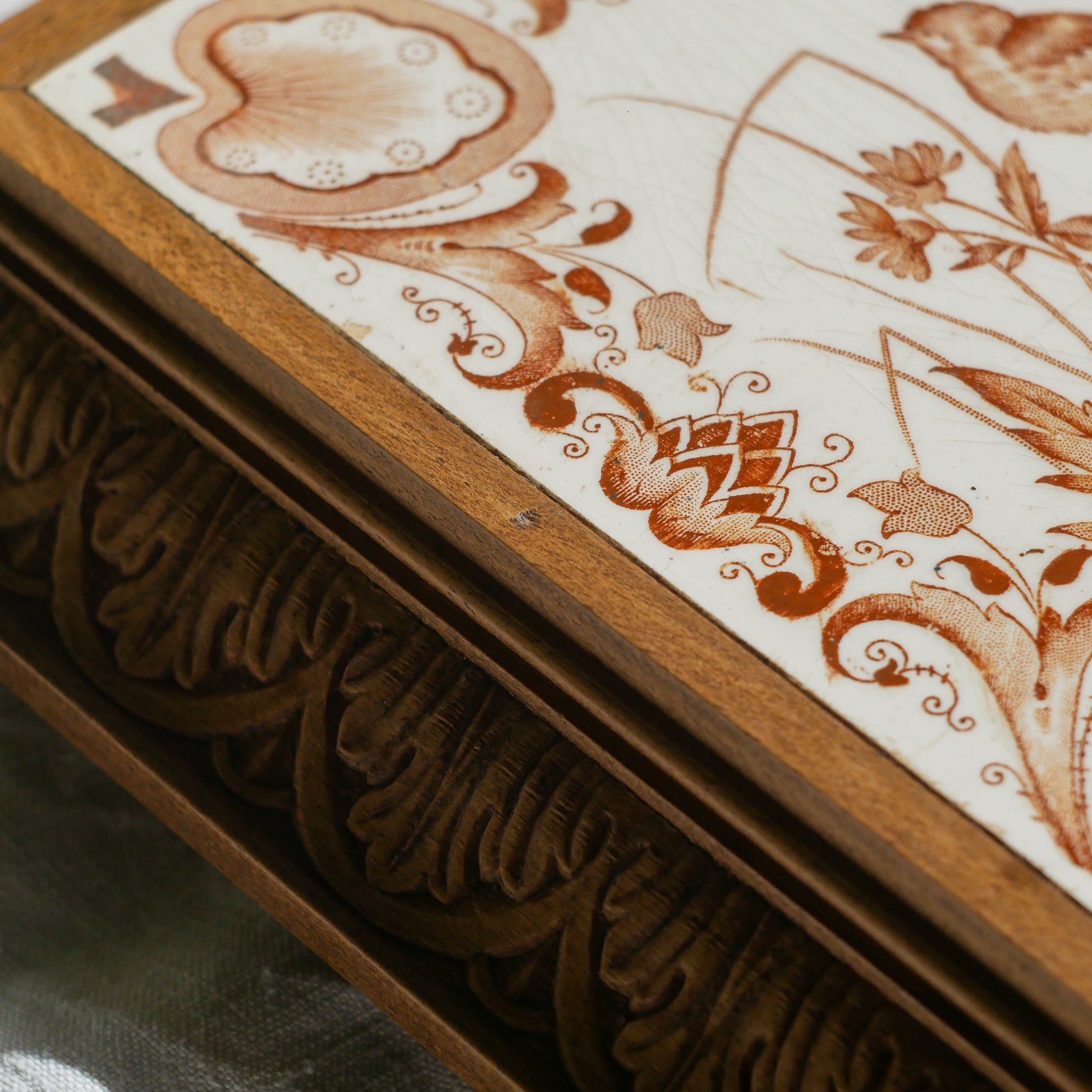 A beautiful French antique wooden trivet with a ceramic bird and floral tile insert. The wooden frame is very decorative with patterns around all four edges while the ceramic tile has aged just enough, the tasteful off-white and light brown colour scheme making this piece a most welcome addition to any kitchen as decor or perhaps as a decorative plant pot stand.