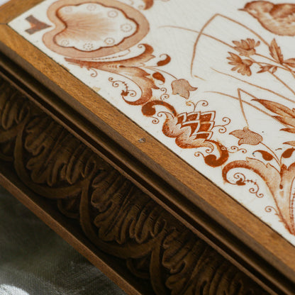 A beautiful French antique wooden trivet with a ceramic bird and floral tile insert. The wooden frame is very decorative with patterns around all four edges while the ceramic tile has aged just enough, the tasteful off-white and light brown colour scheme making this piece a most welcome addition to any kitchen as decor or perhaps as a decorative plant pot stand.