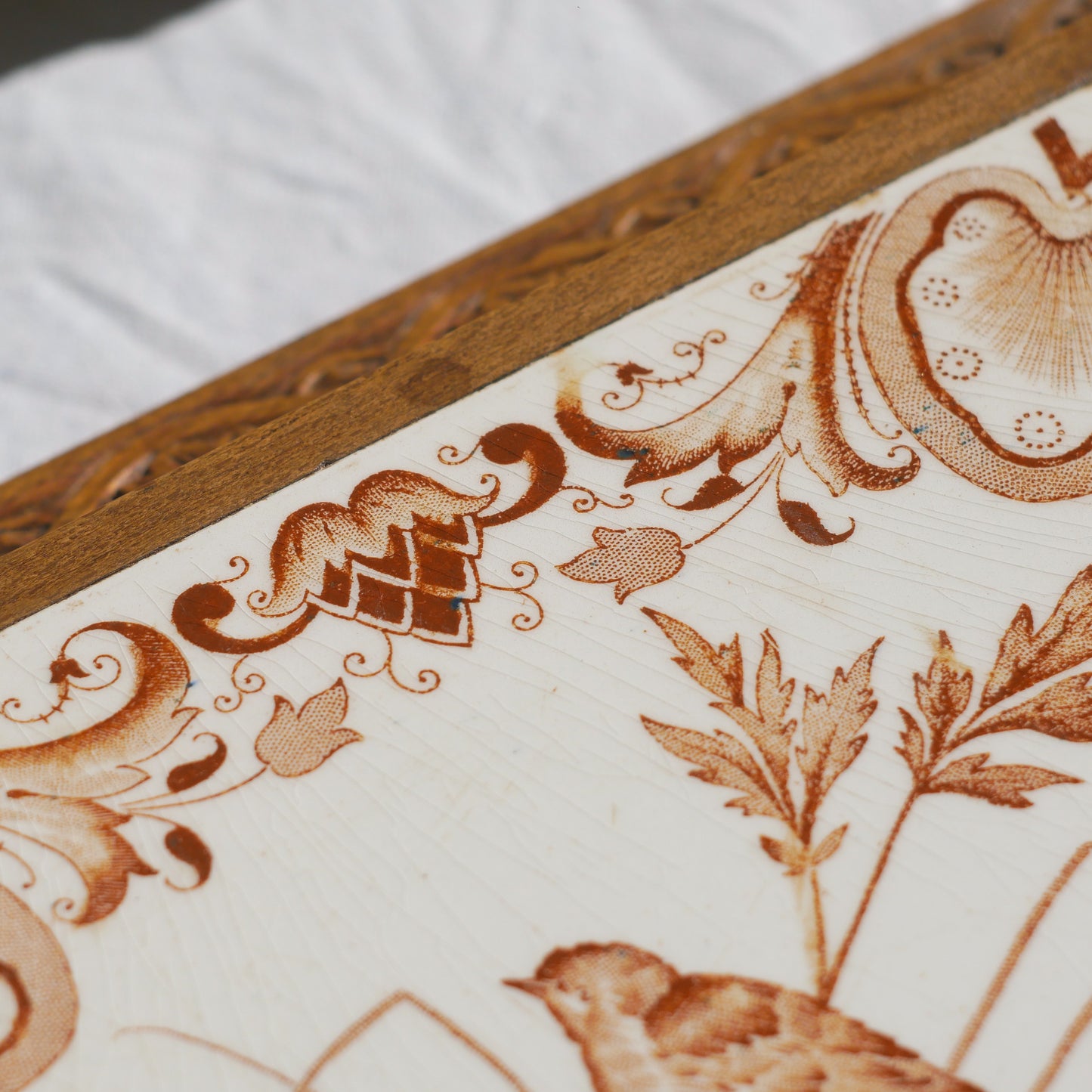 A beautiful French antique wooden trivet with a ceramic bird and floral tile insert. The wooden frame is very decorative with patterns around all four edges while the ceramic tile has aged just enough, the tasteful off-white and light brown colour scheme making this piece a most welcome addition to any kitchen as decor or perhaps as a decorative plant pot stand.