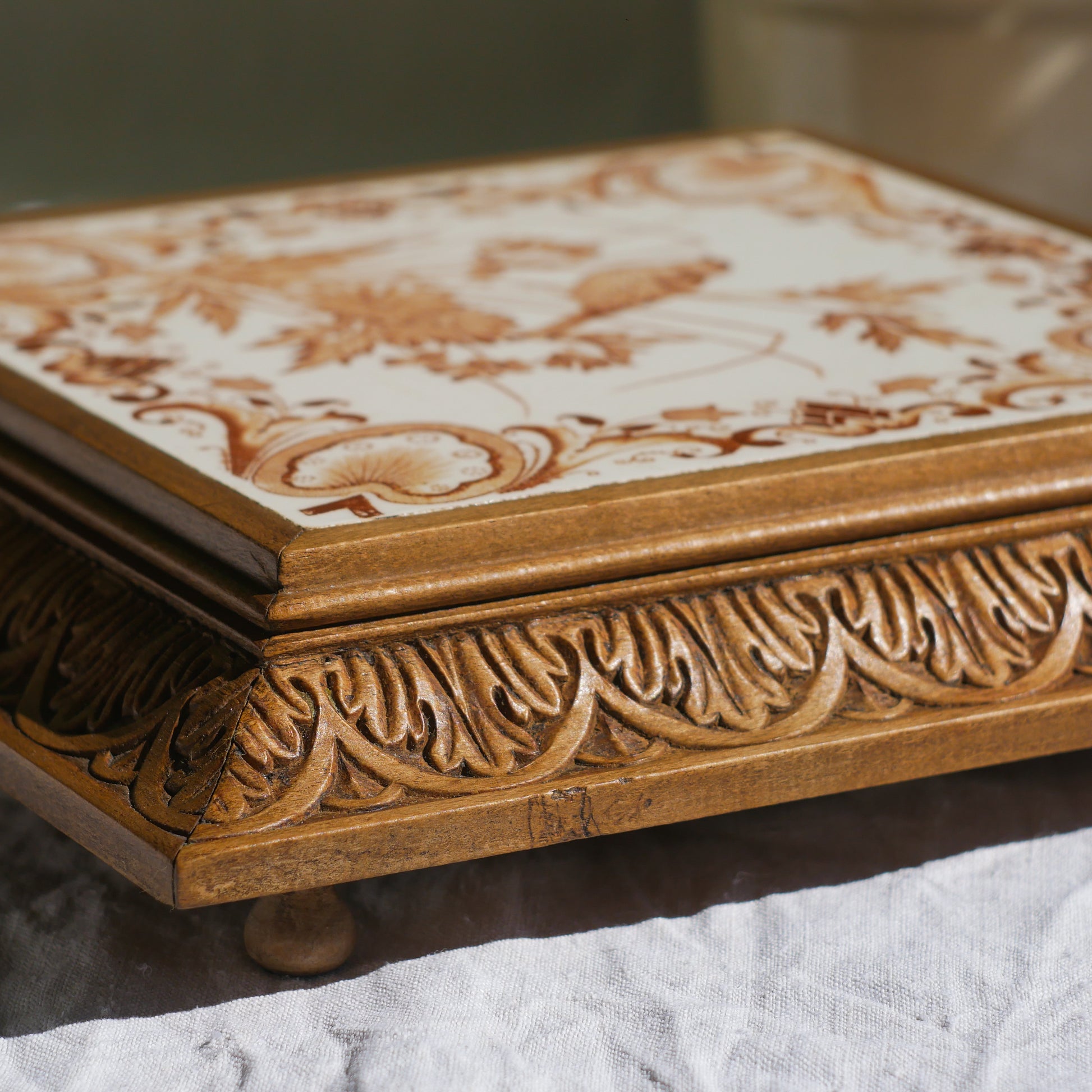 A beautiful French antique wooden trivet with a ceramic bird and floral tile insert. The wooden frame is very decorative with patterns around all four edges while the ceramic tile has aged just enough, the tasteful off-white and light brown colour scheme making this piece a most welcome addition to any kitchen as decor or perhaps as a decorative plant pot stand.