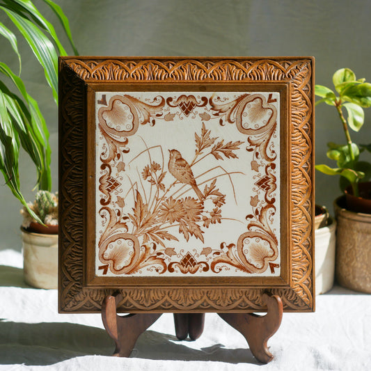 A beautiful French antique wooden trivet with a ceramic bird and floral tile insert. The wooden frame is very decorative with patterns around all four edges while the ceramic tile has aged just enough, the tasteful off-white and light brown colour scheme making this piece a most welcome addition to any kitchen as decor or perhaps as a decorative plant pot stand.