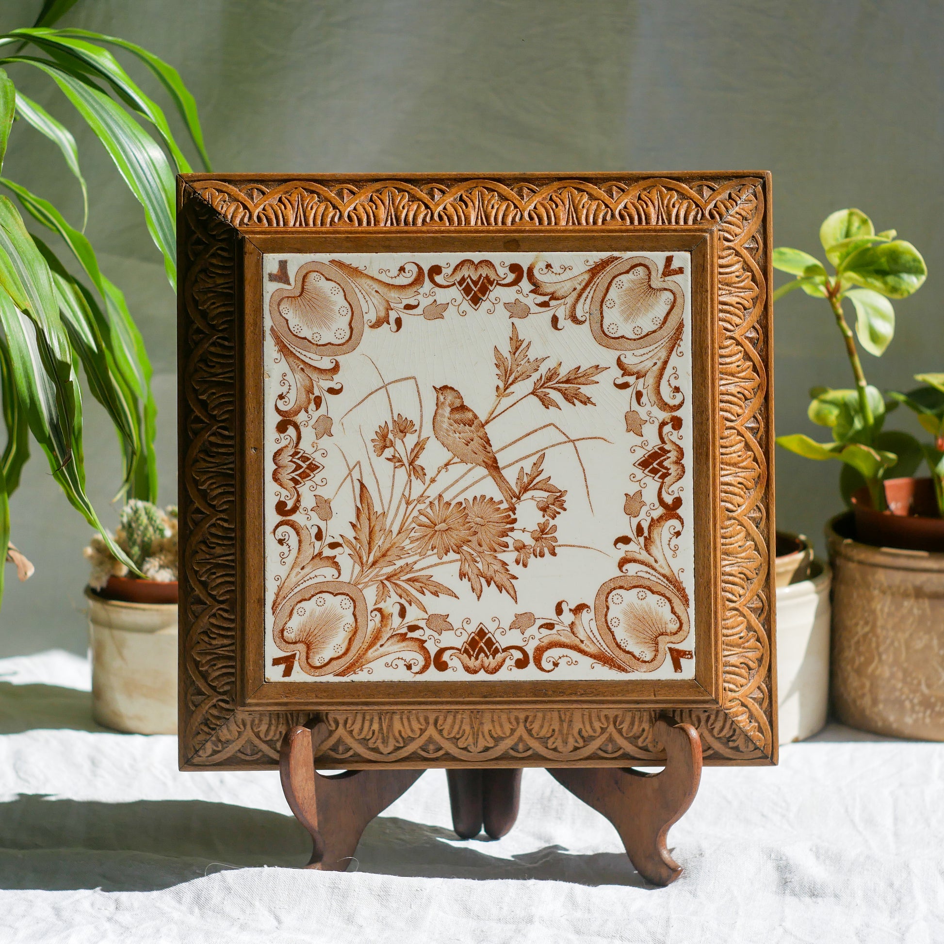 A beautiful French antique wooden trivet with a ceramic bird and floral tile insert. The wooden frame is very decorative with patterns around all four edges while the ceramic tile has aged just enough, the tasteful off-white and light brown colour scheme making this piece a most welcome addition to any kitchen as decor or perhaps as a decorative plant pot stand.