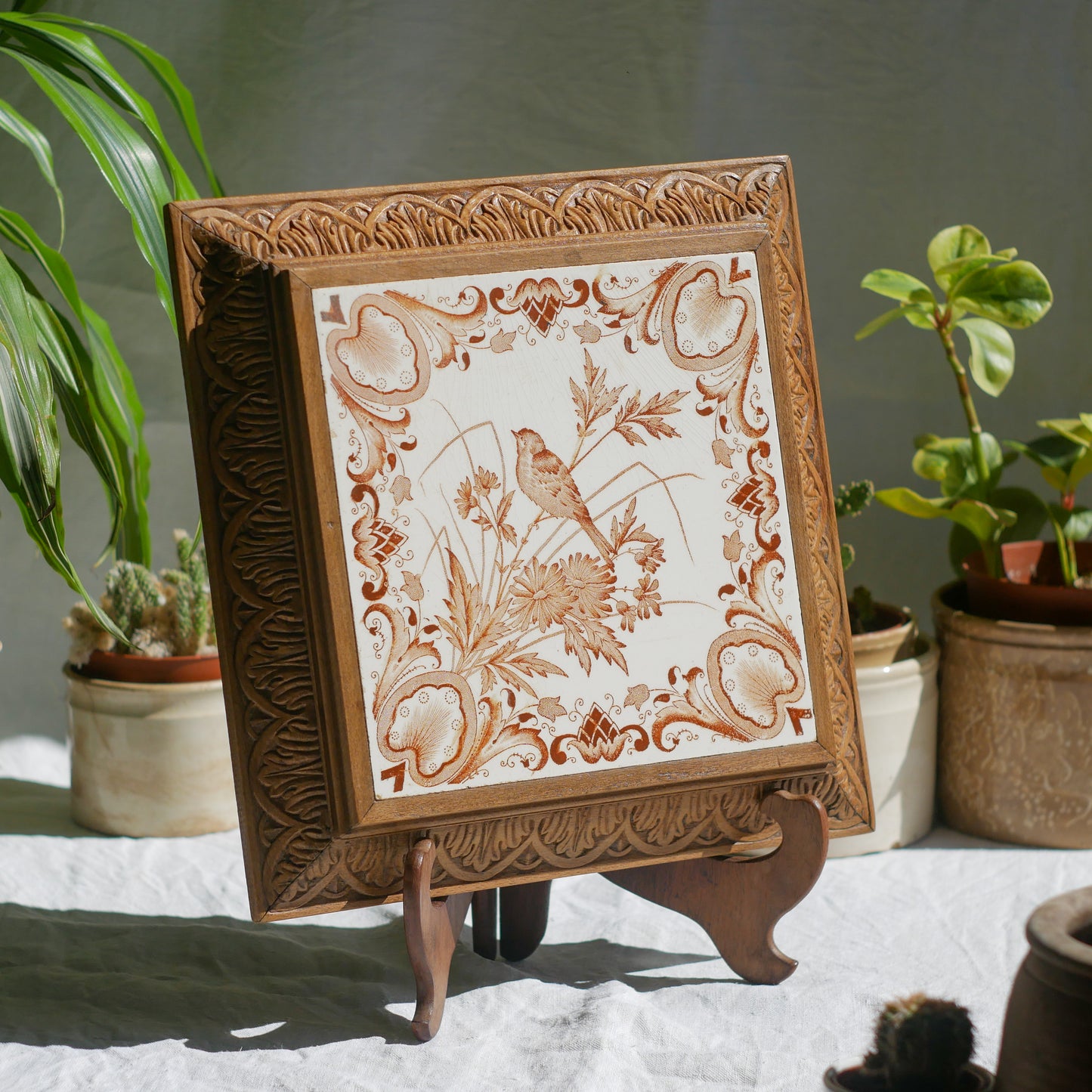 A beautiful French antique wooden trivet with a ceramic bird and floral tile insert. The wooden frame is very decorative with patterns around all four edges while the ceramic tile has aged just enough, the tasteful off-white and light brown colour scheme making this piece a most welcome addition to any kitchen as decor or perhaps as a decorative plant pot stand.