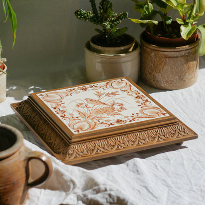 A beautiful French antique wooden trivet with a ceramic bird and floral tile insert. The wooden frame is very decorative with patterns around all four edges while the ceramic tile has aged just enough, the tasteful off-white and light brown colour scheme making this piece a most welcome addition to any kitchen as decor or perhaps as a decorative plant pot stand.