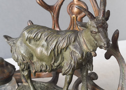 A stunning French art nouveau double inkwell with a goat figurine.

This wonderful antique inkwell has been sculpted in metal and signed by the artist (see photos). Behind the beautiful goat figurine are two pen rests and either side of the goat are two small glass ink pots with decorative metal lids.

The metal is finished in a lovely shade of green that has worn over time with traces of gold colour beneath - it has a wonderful patina of time all over it.