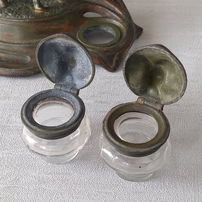 A stunning French art nouveau double inkwell with a goat figurine.

This wonderful antique inkwell has been sculpted in metal and signed by the artist (see photos). Behind the beautiful goat figurine are two pen rests and either side of the goat are two small glass ink pots with decorative metal lids.

The metal is finished in a lovely shade of green that has worn over time with traces of gold colour beneath - it has a wonderful patina of time all over it.