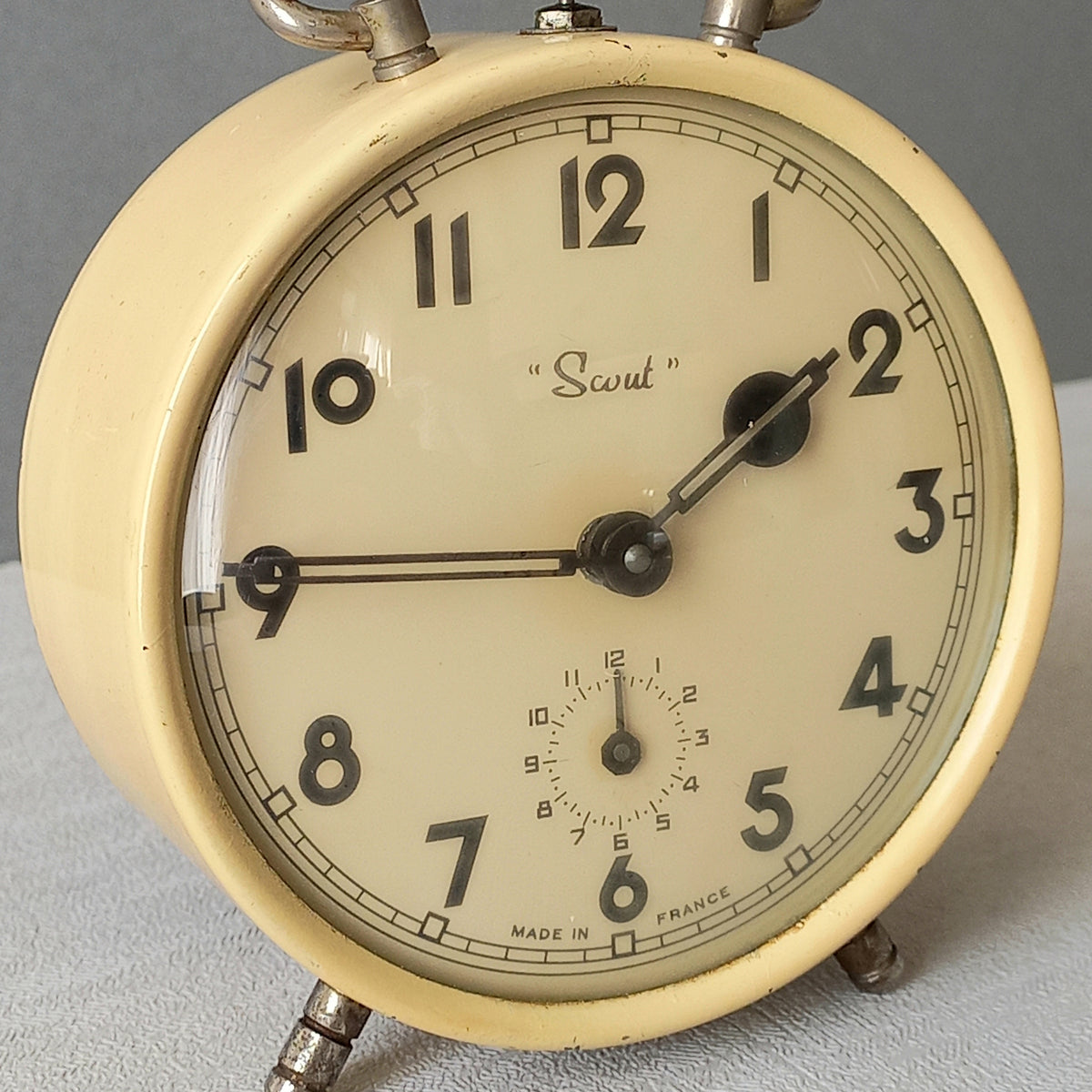 A wonderful French vintage alarm clock in a lovely shade of cream called 'Scout'.

This old clock is in working condition including the alarm and has a nice soothing ticking sound too.

The clock's metal case has a finish that has slight discoloring in places and paint chips (mainly to the rear - see photos) which gives it character.

In summary, a nice vintage alarm clock from France!