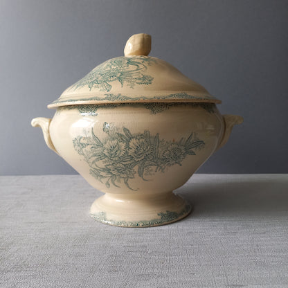A pretty antique ironstone soup tureen with aged and faded floral transfer pattern in a beautiful shade of blue green or teal. Over time this wonderful old tureen has developed a pleasing faded creamy white finish. In summary, a beautiful piece of authentic antique ironstone from France.