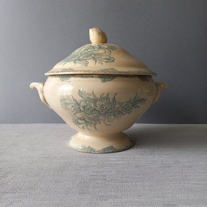A pretty antique ironstone soup tureen with aged and faded floral transfer pattern in a beautiful shade of blue green or teal. Over time this wonderful old tureen has developed a pleasing faded creamy white finish. In summary, a beautiful piece of authentic antique ironstone from France.