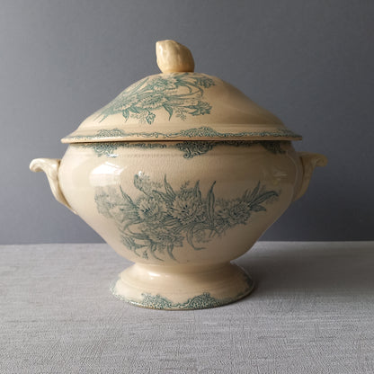 A pretty antique ironstone soup tureen with aged and faded floral transfer pattern in a beautiful shade of blue green or teal. Over time this wonderful old tureen has developed a pleasing faded creamy white finish. In summary, a beautiful piece of authentic antique ironstone from France.