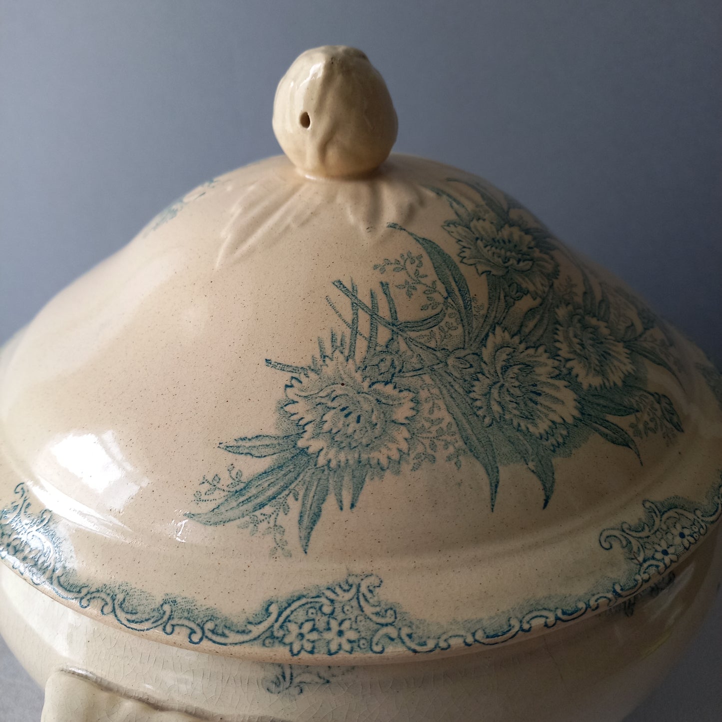 A pretty antique ironstone soup tureen with aged and faded floral transfer pattern in a beautiful shade of blue green or teal. Over time this wonderful old tureen has developed a pleasing faded creamy white finish. In summary, a beautiful piece of authentic antique ironstone from France.