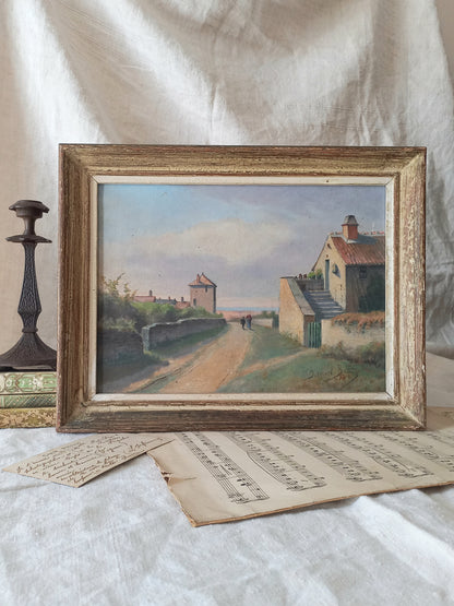 Framed painting of a village scene on a textured surface with sheet music.