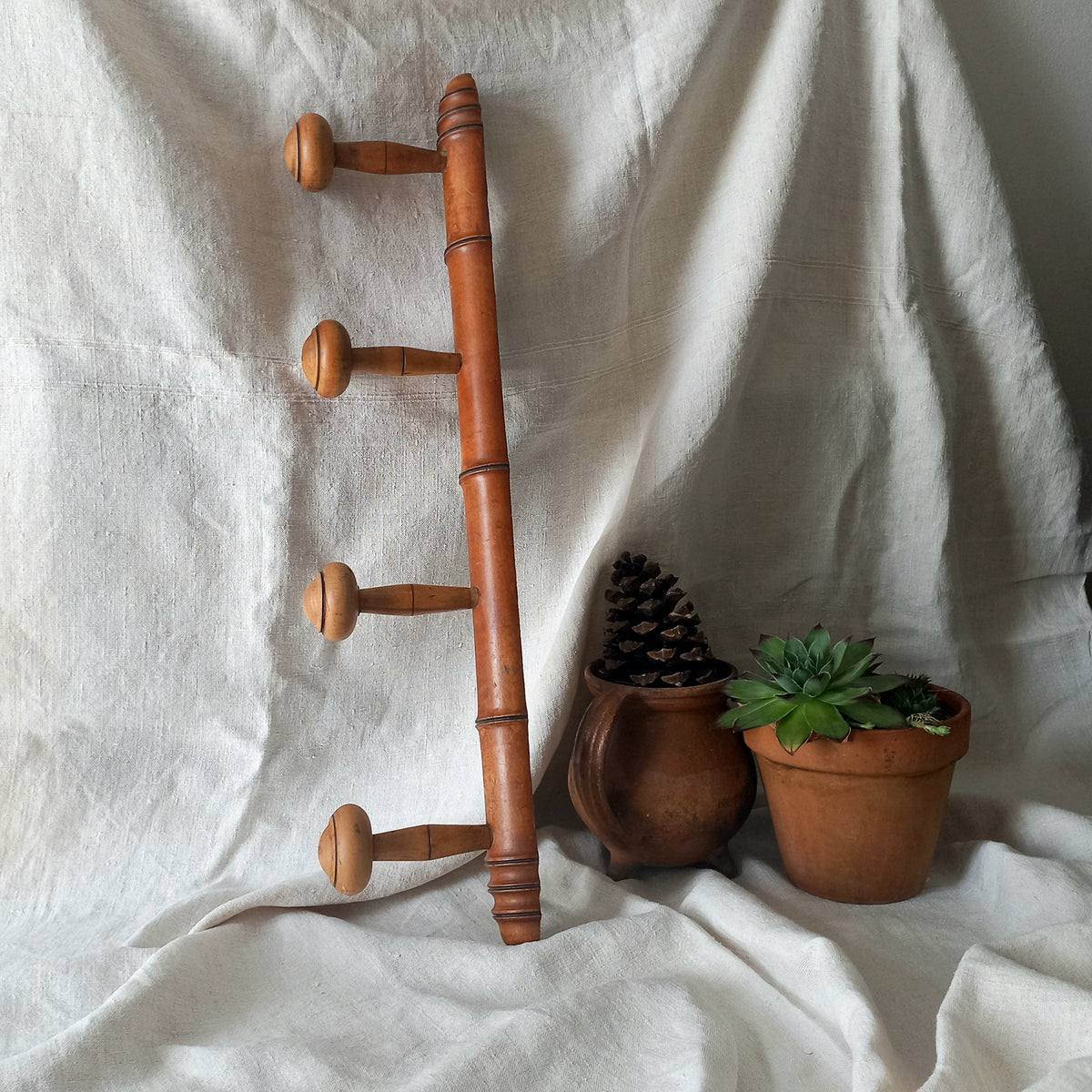 A French vintage faux bamboo wooden coat rack with 4 hanging hooks/pegs. These older type of faux bamboo coat racks are becoming increasingly difficult to source, especially in this excellent condition! There are two metal hanging hooks to the rear for mounting to your wall.

In summary, a wonderful piece of wall decor for any interior, and especially those of a country home, rustic or farmhouse style.