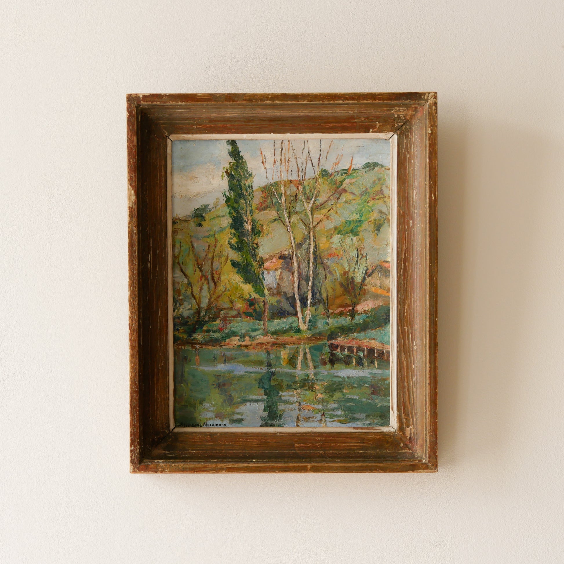 An original vintage landscape oil painting depicting a charming country home in among a wooded area with hills in the background. In the foreground a gentle river reflects the trees in the background.

The painting has been painted by an experienced artist with confident brush strokes - a really wonderful piece of original art.

The painting is presented in an old worn wooden frame which we love and think others will too - it really suits this piece. 