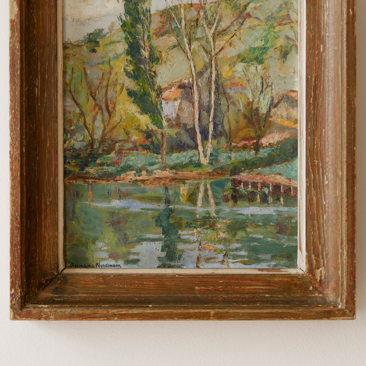 An original vintage landscape oil painting depicting a charming country home in among a wooded area with hills in the background. In the foreground a gentle river reflects the trees in the background.

The painting has been painted by an experienced artist with confident brush strokes - a really wonderful piece of original art.

The painting is presented in an old worn wooden frame which we love and think others will too - it really suits this piece. 