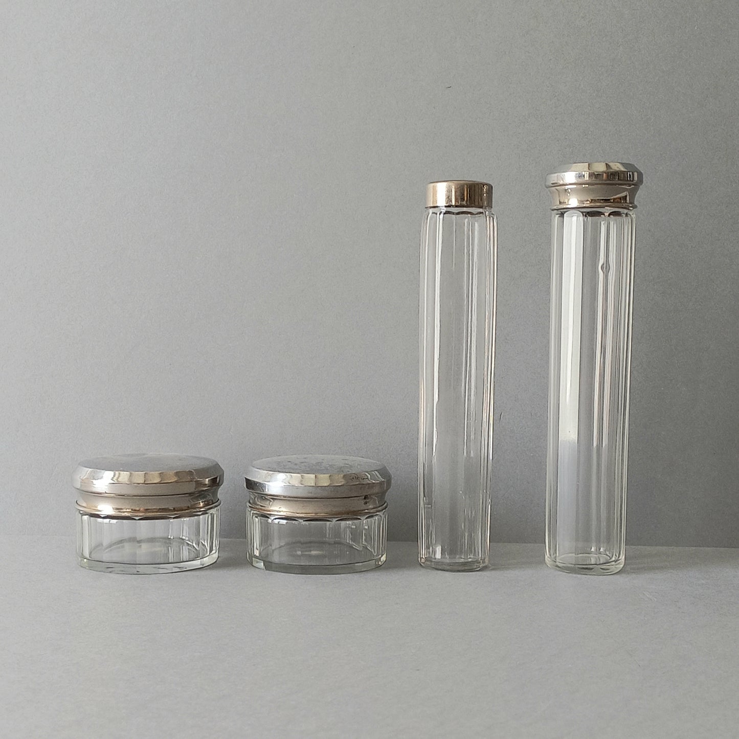 A set of 4 small French vintage decorative glass perfume/scent bottles/make-up containers that will make pleasing decorative pieces in your interior.