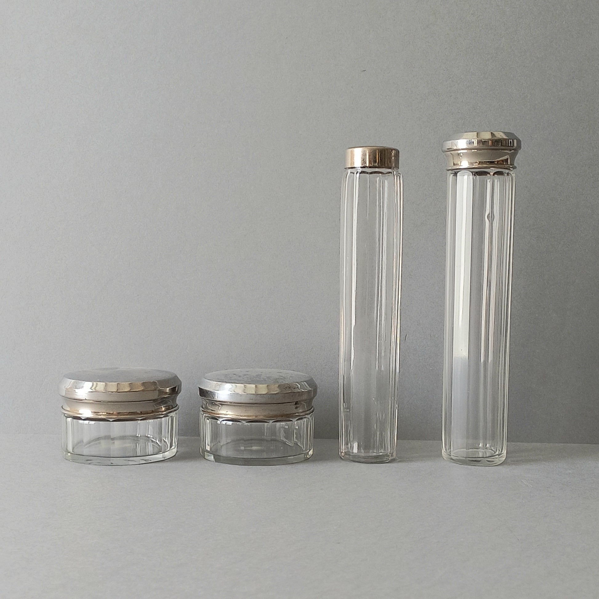 A set of 4 small French vintage decorative glass perfume/scent bottles/make-up containers that will make pleasing decorative pieces in your interior.