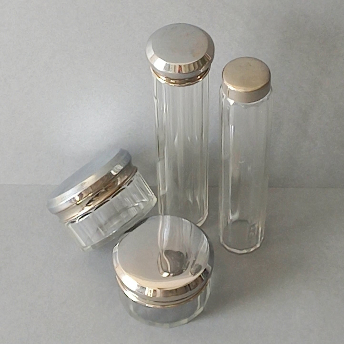 A set of 4 small French vintage decorative glass perfume/scent bottles/make-up containers that will make pleasing decorative pieces in your interior.