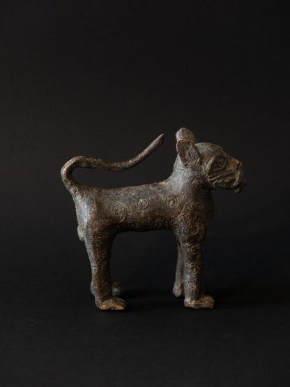 Bronze figurine of a standing animal on a black background
