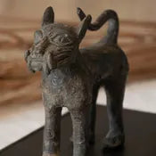 Bronze cat figurine on a wooden surface